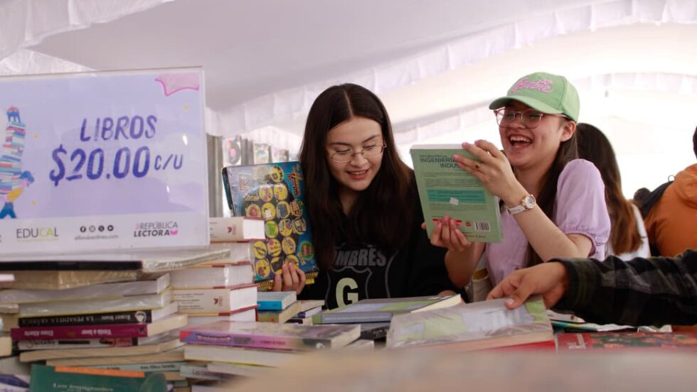 Jóvenes revisan libros durante el 22º Gran Remate de Libros, Discos y Películas en el Monumento a la Revolución